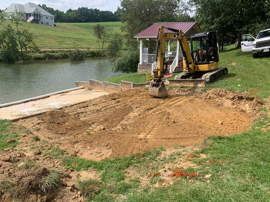 Site excavation with CAT excavator for lakeside paver patio